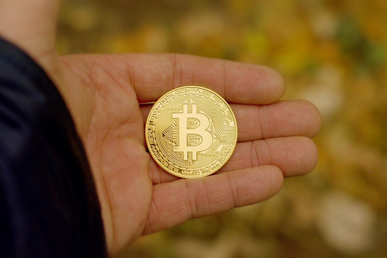Man holding fictional bitcoin currency in his hand
