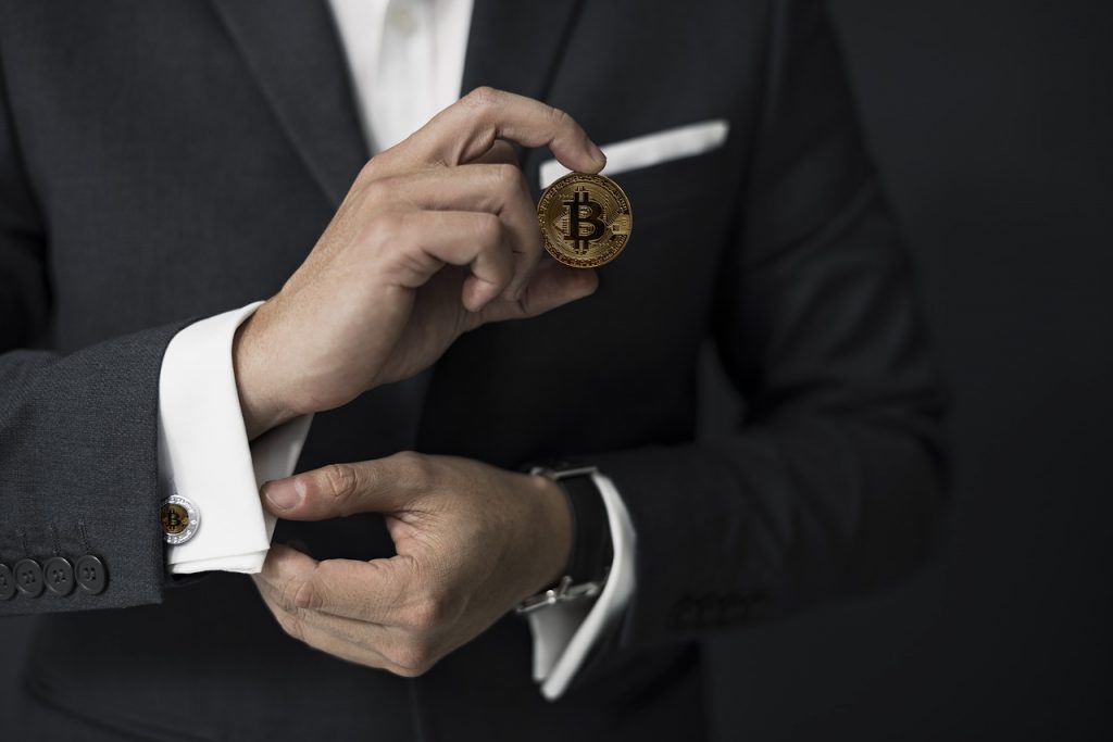 Picture of man holding bitcoin