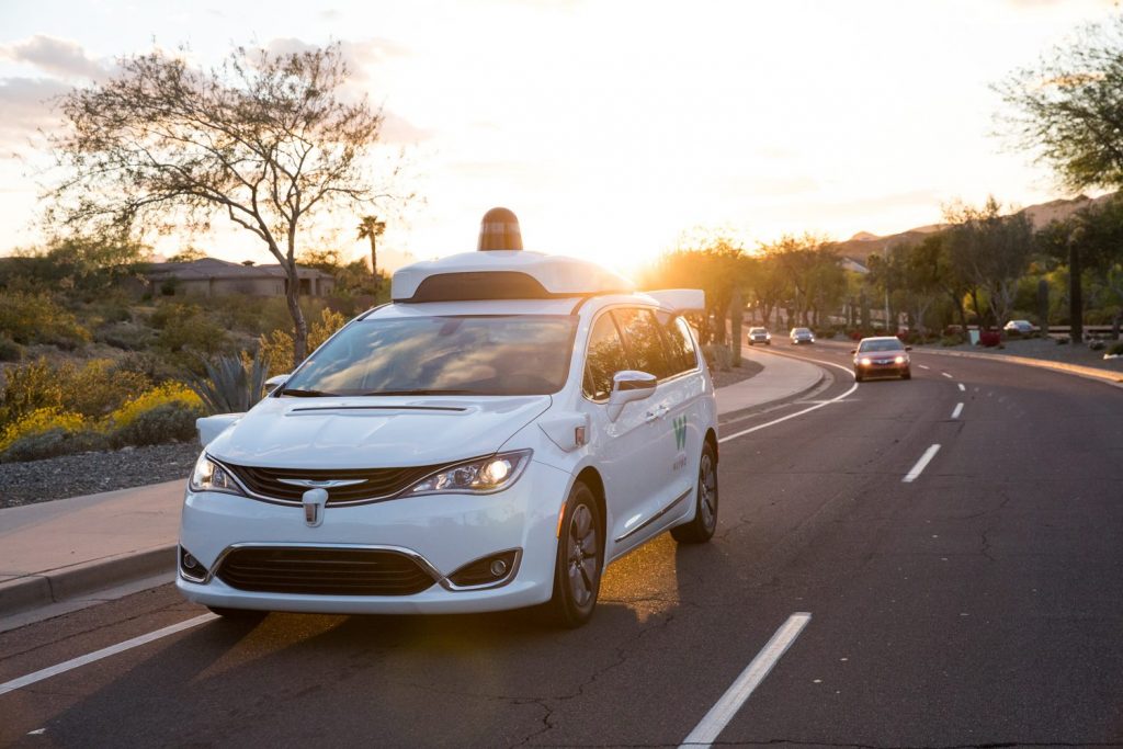 Waymo One van on road.